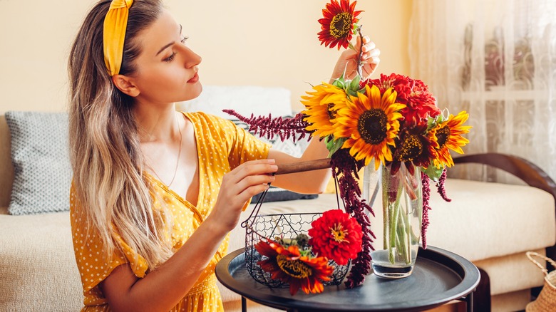 Woman arranging autumn flower bouquet