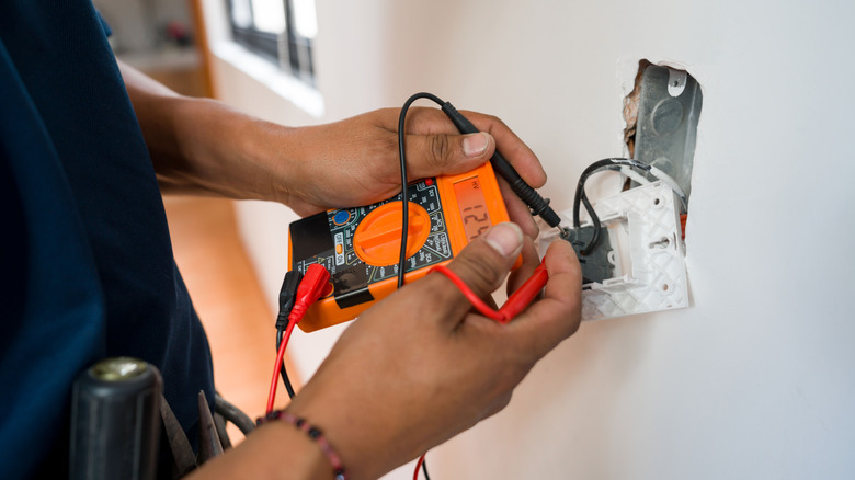 electrician measuring wire voltage