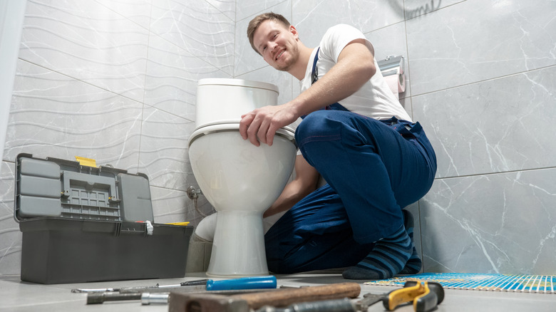 A plumber installing a toilet 