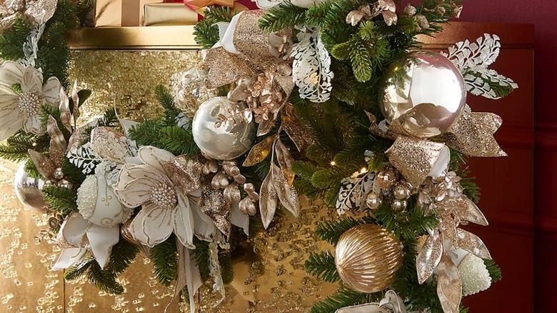 Glitzy and detailed gold and white wreath draped across a gold mantle