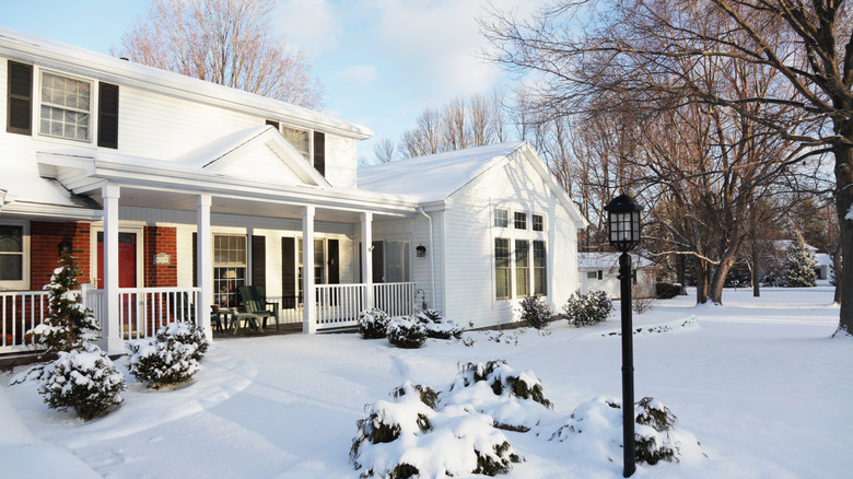 A white house with a snow-filled yard