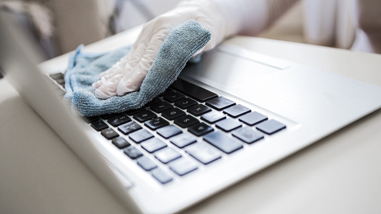 Person cleaning laptop keyboard