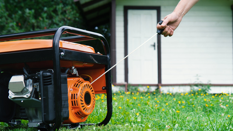 person starting portable home generator 