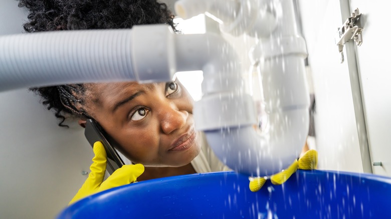 Woman examines broken pipes