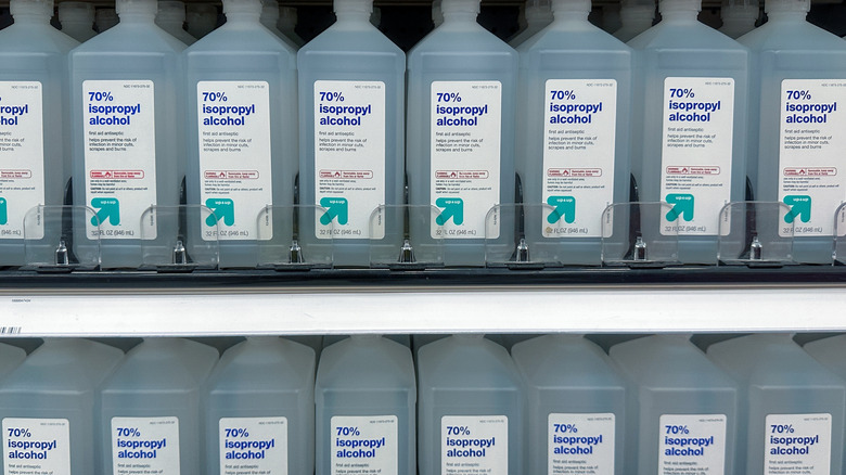 Bottles of isopropyl alcohol lined up on a store shelf.