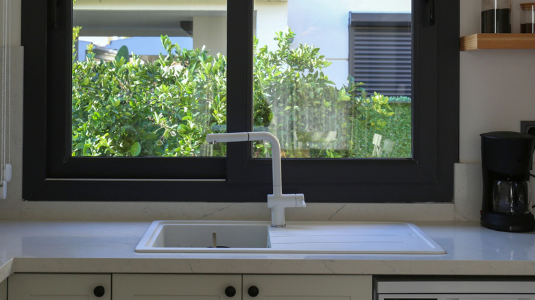 Pull-out kitchen faucet above kitchen sink