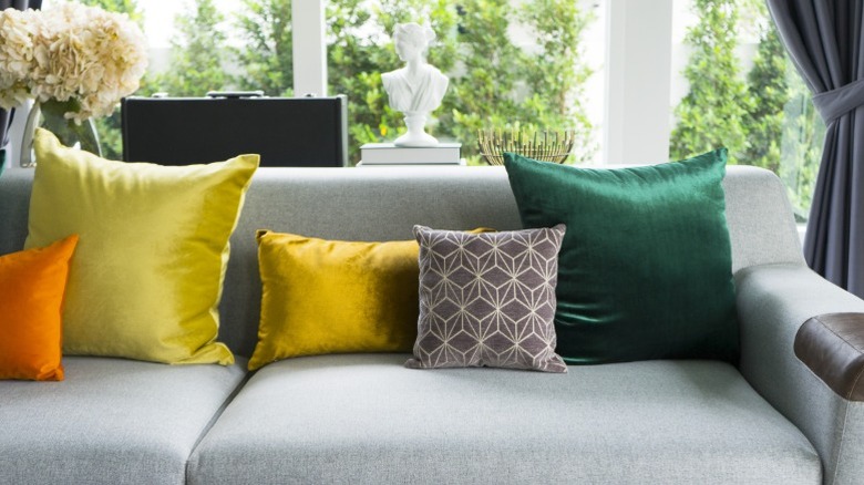 Assorted throw pillows of different colors on gray sofa