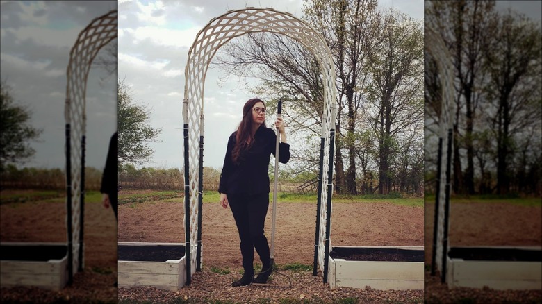 woman standing under garden archway