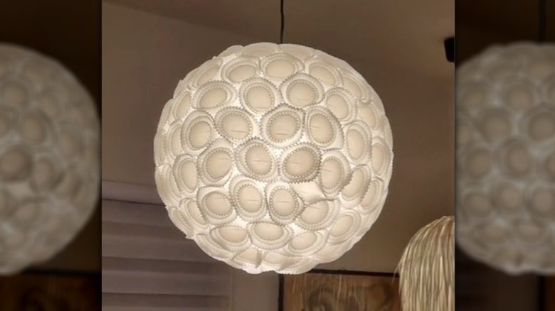 White textured lamp with a soft glow hung in a living room or study