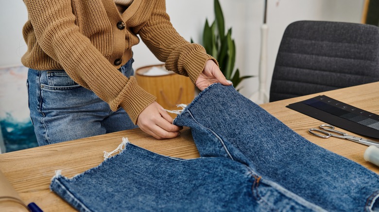 Woman folding legs of jeans to upcycle