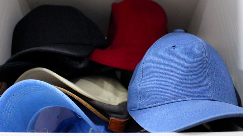 baseball caps stacked in closet