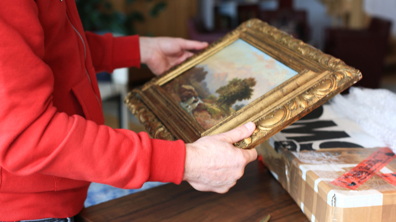 Person holding old wall art