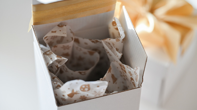 A white gift box with printed tissue paper inside