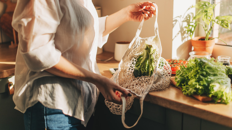 Someone opening a mesh fruit bag