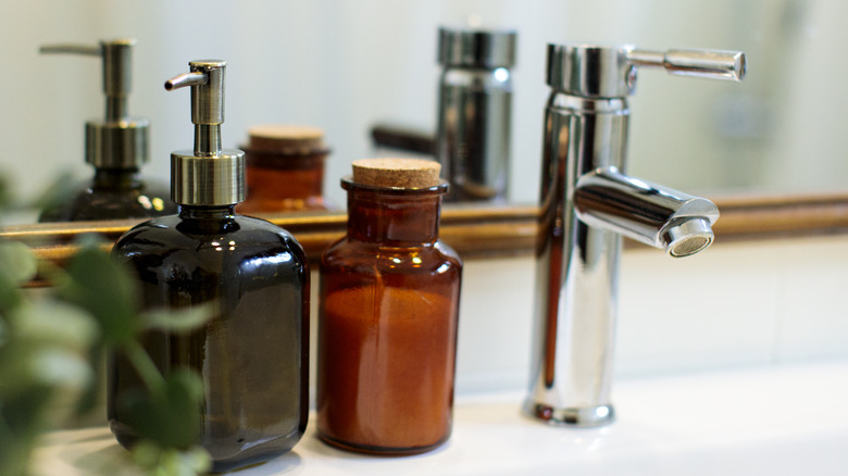 Mini amber bottle filled with epsom salt next to sink.