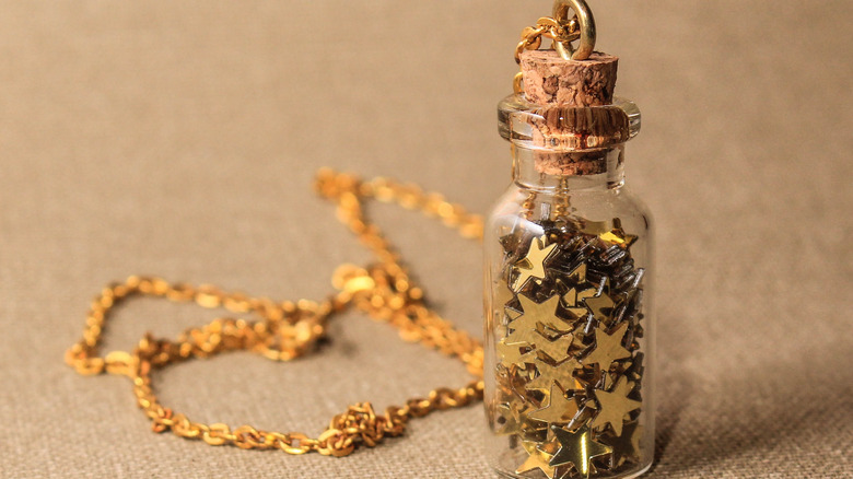 Close up of tiny bottle filled with gold stars.