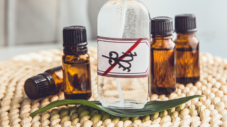 Bottle with anti-mosquito sign surrounded by essential oil bottles.