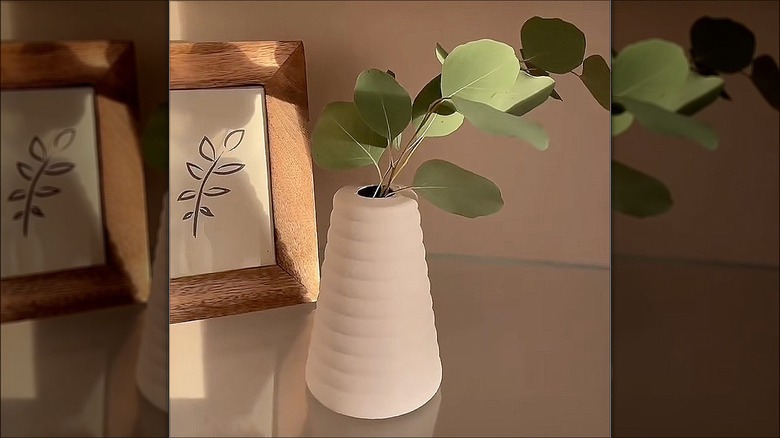 Close-up of a vase made from a spray bottle with a stem