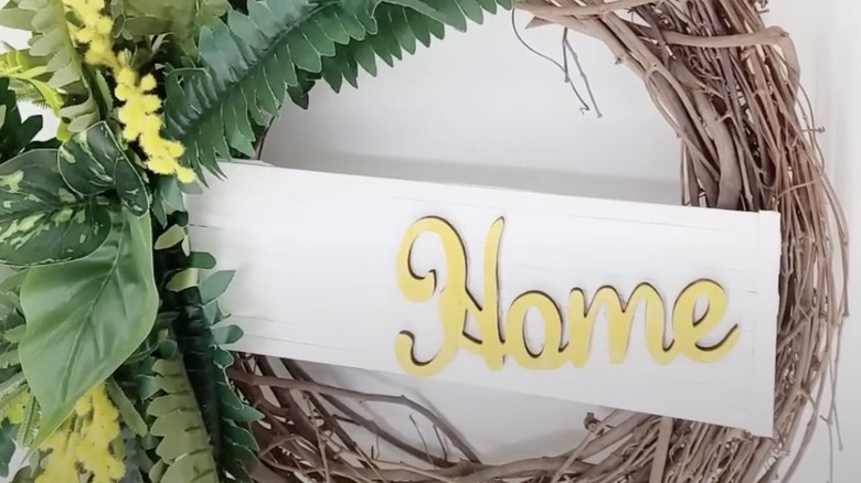 Decorative sign made from cardboard, wooden dowels, and wood letters