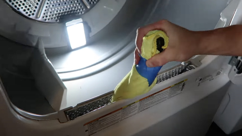 A dryer lint trap brush made by affixing a microfiber cloth to a screwdriver with duct tape.