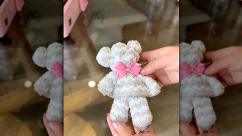 A teddy bear made by folding a microfiber cloth and adding a bow.