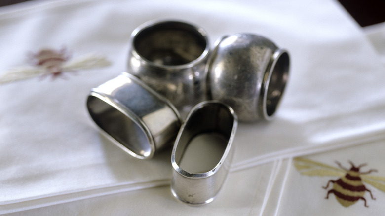 A few old napkin rings sitting on napkins