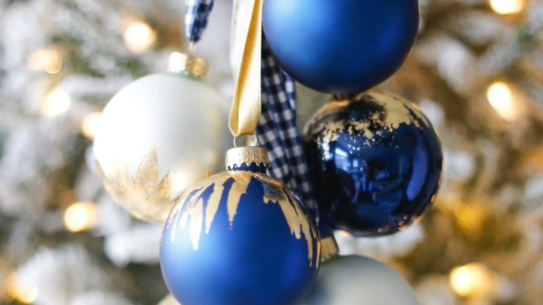 Blue and white ornaments with gold leaf accents strung on a ribbon