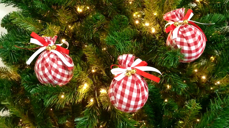 Three Buffalo plaid-wrapped ornaments in Christmas tree