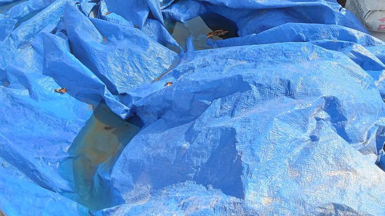 Blue tarp with water pooled over it