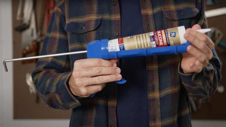 removing caulk tube from gun