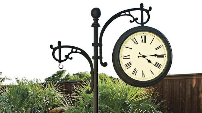 outdoor pedestal clock by pool