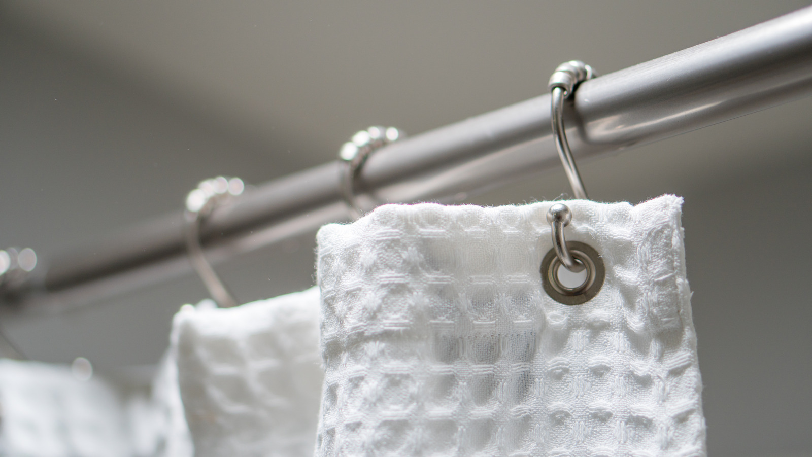 https://www.housedigest.com/img/gallery/double-your-showers-storage-space-with-this-simple-curtain-rod-hack/l-intro-1688667201.jpg