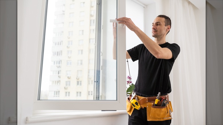 A young worker installs a new window