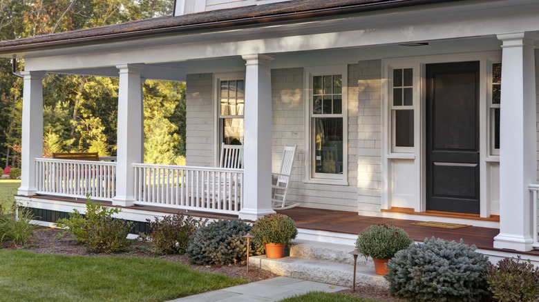 A large white home featuring an open-air veranda