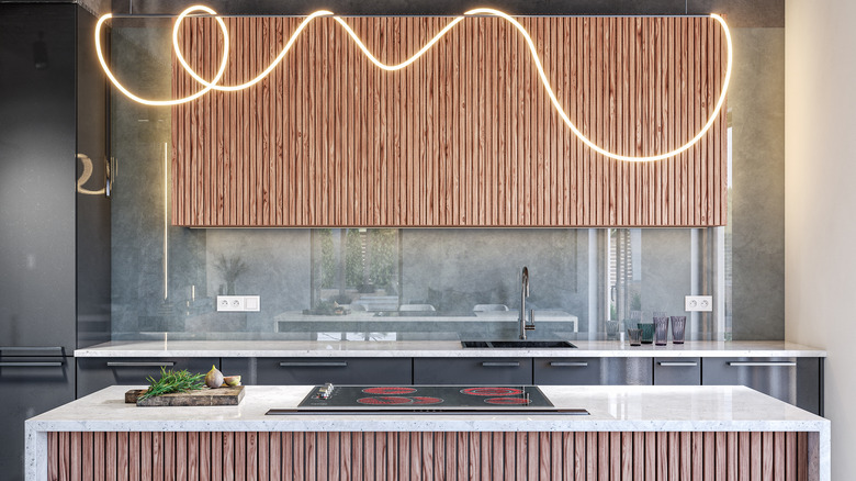 A kitchen with fluted upper cabinets and island