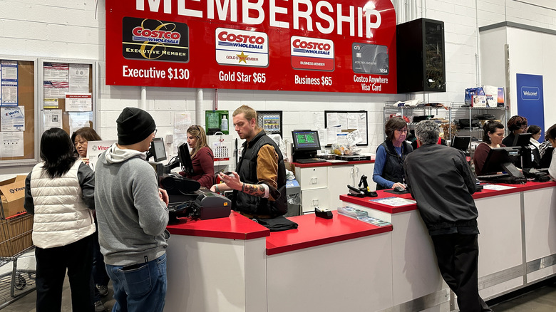 Costco customers speaking to employees at membership counter