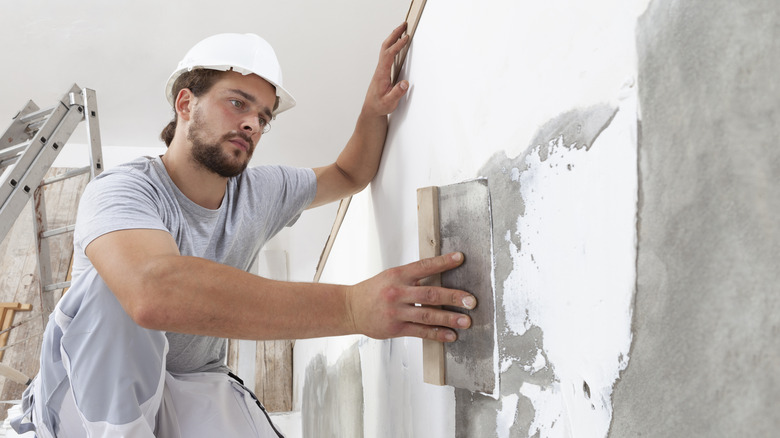 man plastering wall