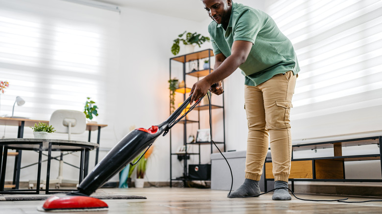 Man vacuuming a floor