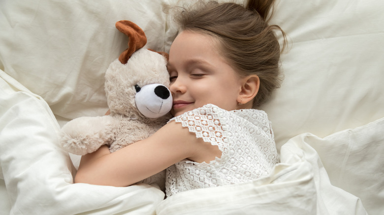 little girl snuggling teddy bear