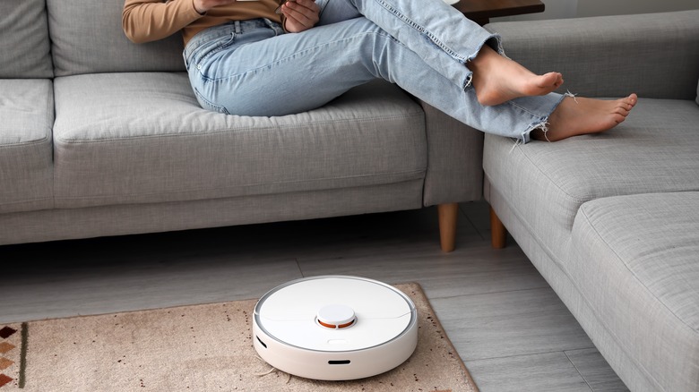 Robot vacuum cleaner by couch