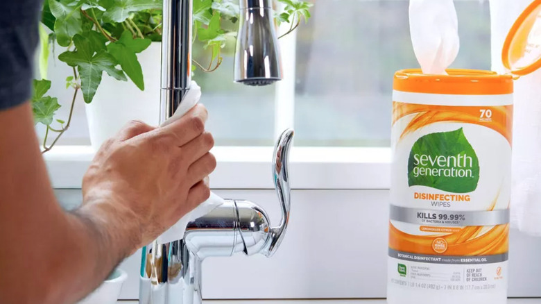 Man cleaning sink with wipes