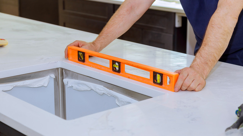 Person measuring kitchen sink