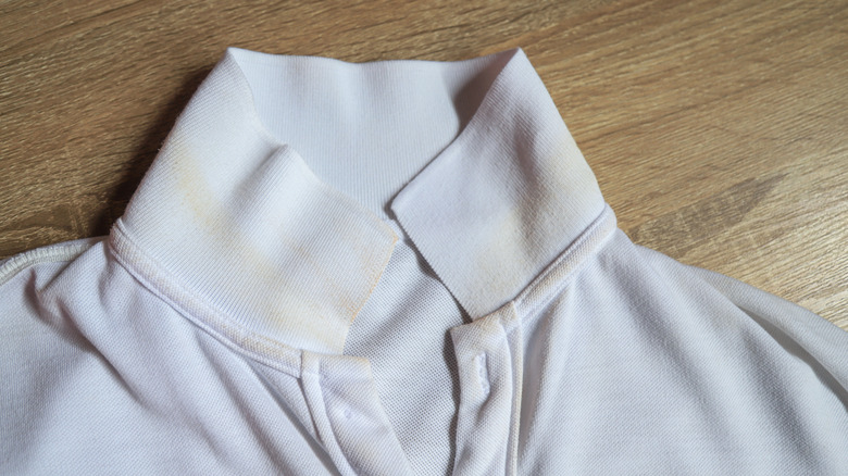 A sweat stain on the collar of a white polo shirt