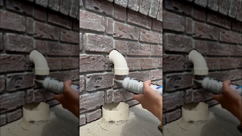person adding caulk to brick veneer