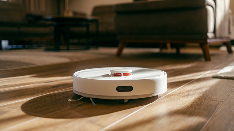 Robot vacuum cleaning the floor with bristles.