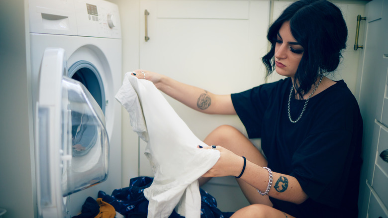 woman holding t-shirt beside dryer