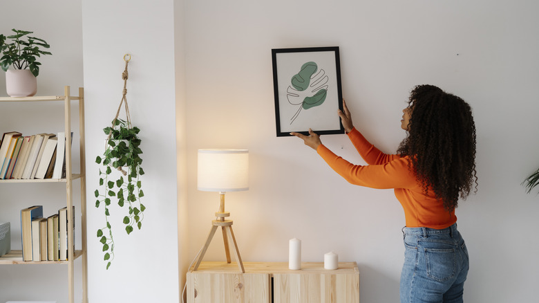 woman hanging a picture frame