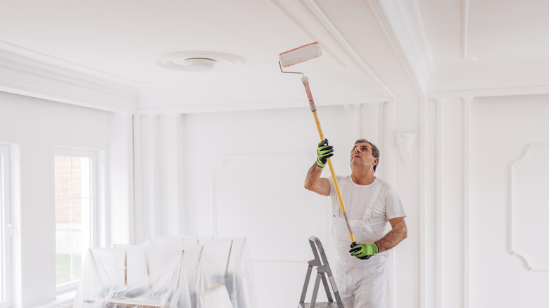 man painting a home's ceiling