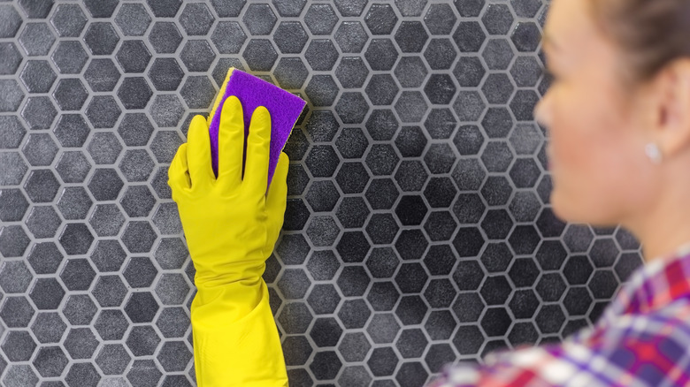 Woman wipes down kitchen backsplash