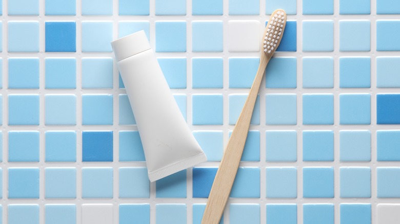 toothbrush and toothpaste on tile